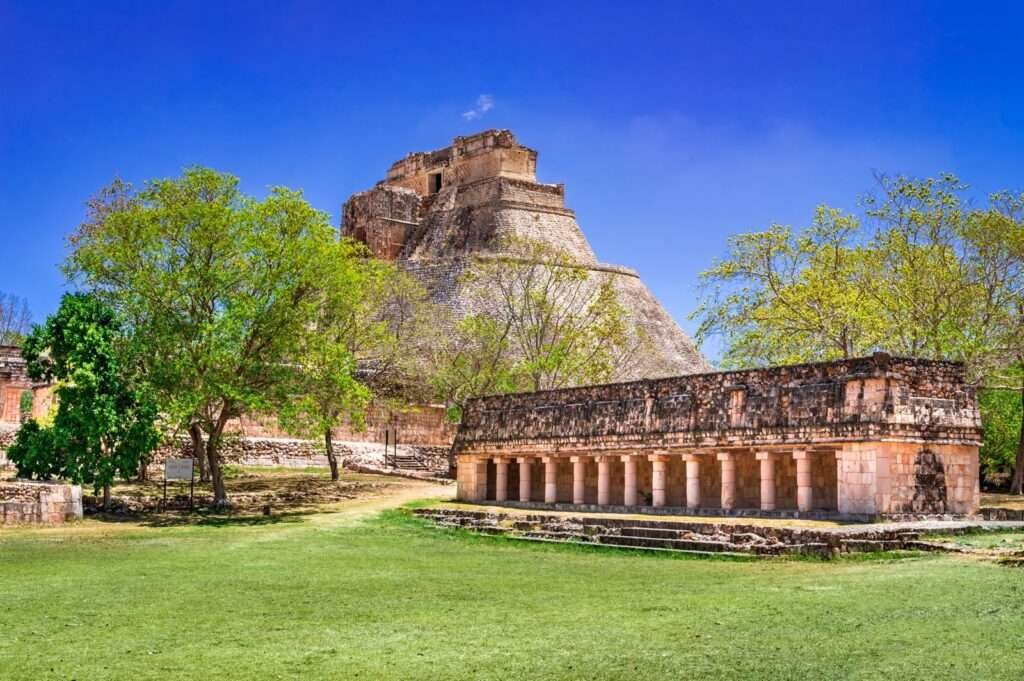 Die Pyramide des Zauberers und das Nonnenviereck in den Ruinen von Uxmal, eingebettet in grüne Vegetation