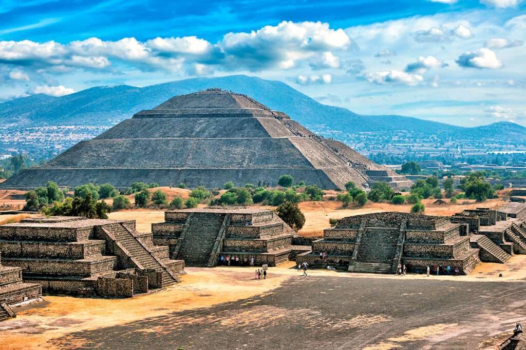 Weitwinkelansicht der Ruinen von Teotihuacan mit der Sonnenpyramide unter blauem Himmel