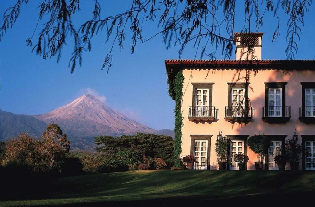 Blick auf eine koloniale Hacienda in Mexiko mit Vulkan im Hintergrund – idealer Standort für nachhaltigen Immobilienkauf in Mexiko.
