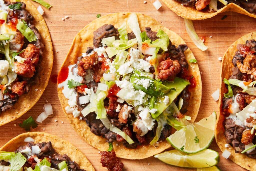 Knusprige Tostadas mit Bohnen, Avocado, Käse und Chorizo