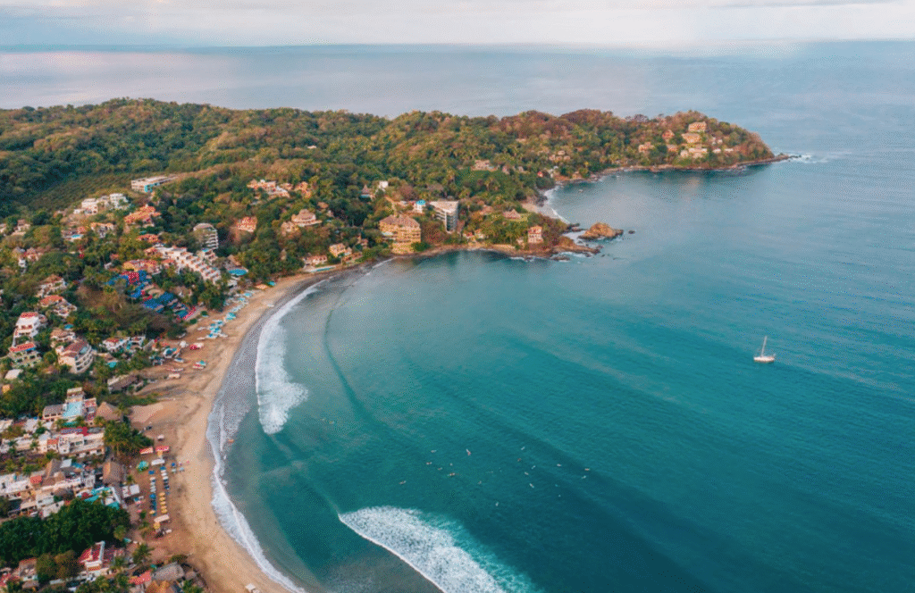 Luftbild von Sayulita mit Strand, Wellen und Häusern