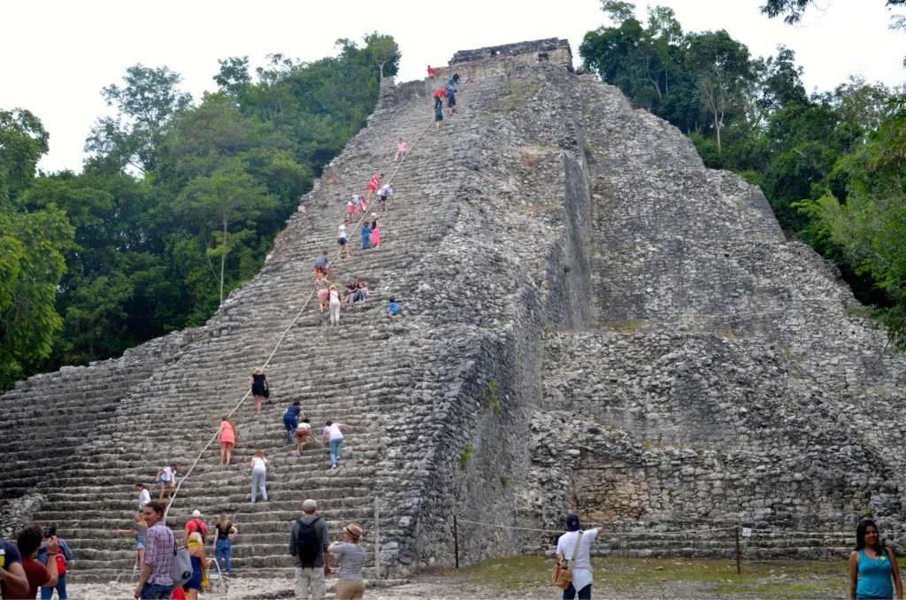 Besucher erklimmen die steilen Treppen der Ruinen von Cobá in Quintana Roo