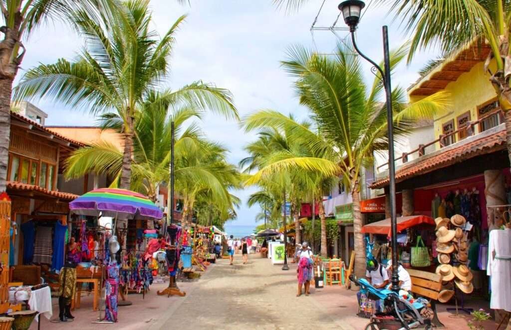 Bunte Marktstraße unter Palmen im Zentrum von Sayulita