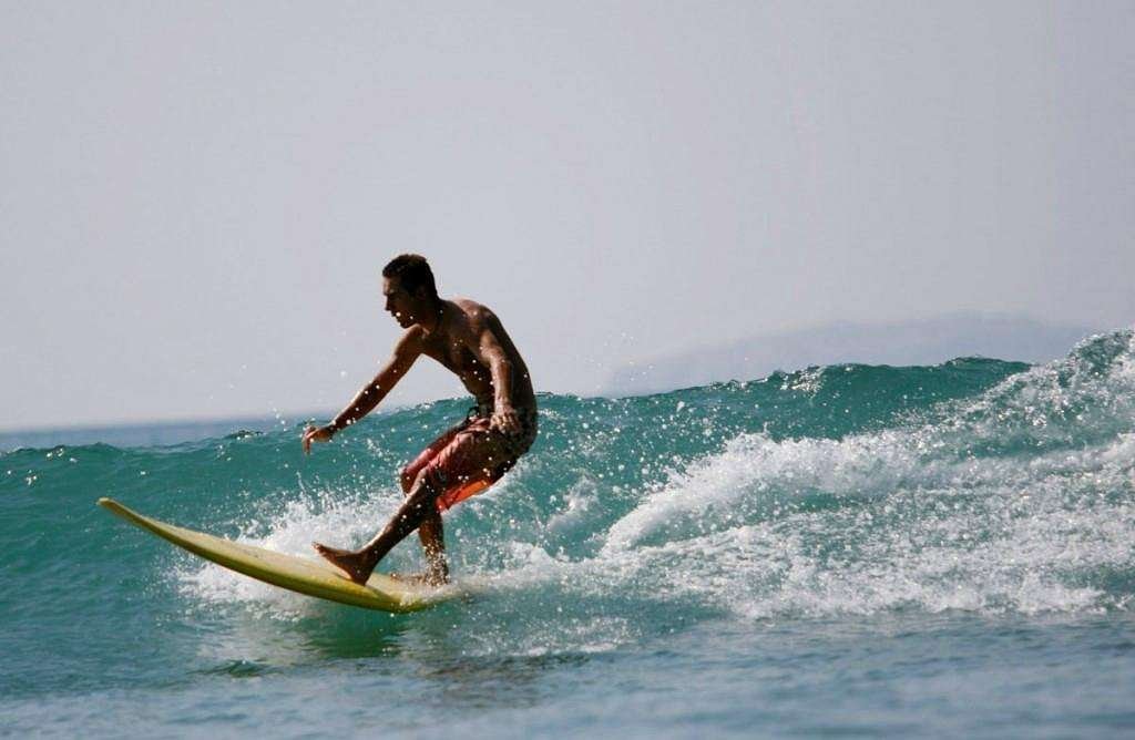 Surfer auf einer Welle am Hauptstrand von Sayulita