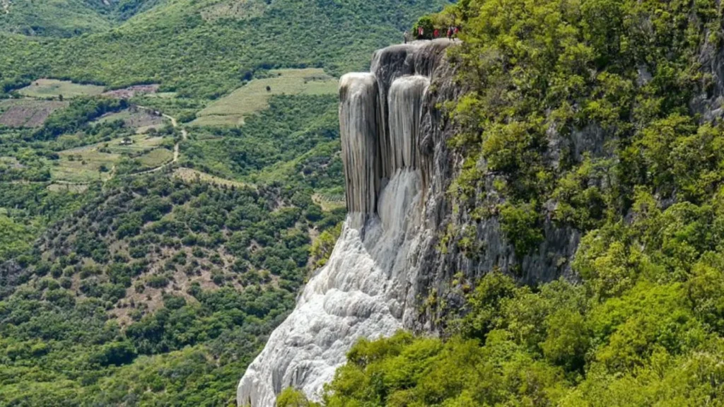 Natürlicher versteinerter Wasserfall in Oaxaca Mexiko vor grüner Berglandschaft