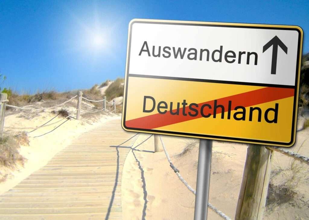 Ortsschild mit Auswandern und durchgestrichenem Deutschland – passend zu Warum viele Menschen nie auswandern
